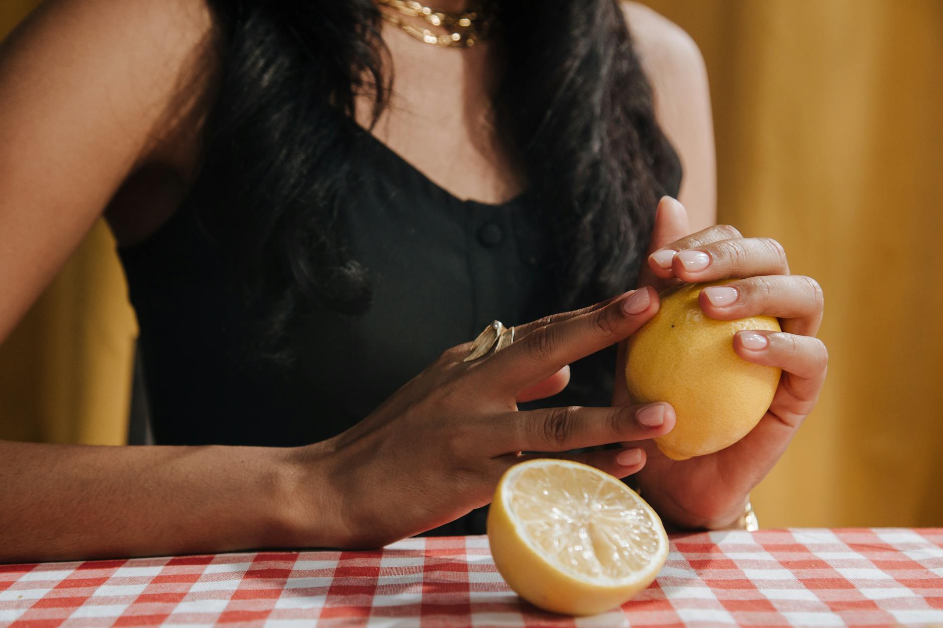 Close-up of hands holding a sleek clitoral vibrator against a purple background