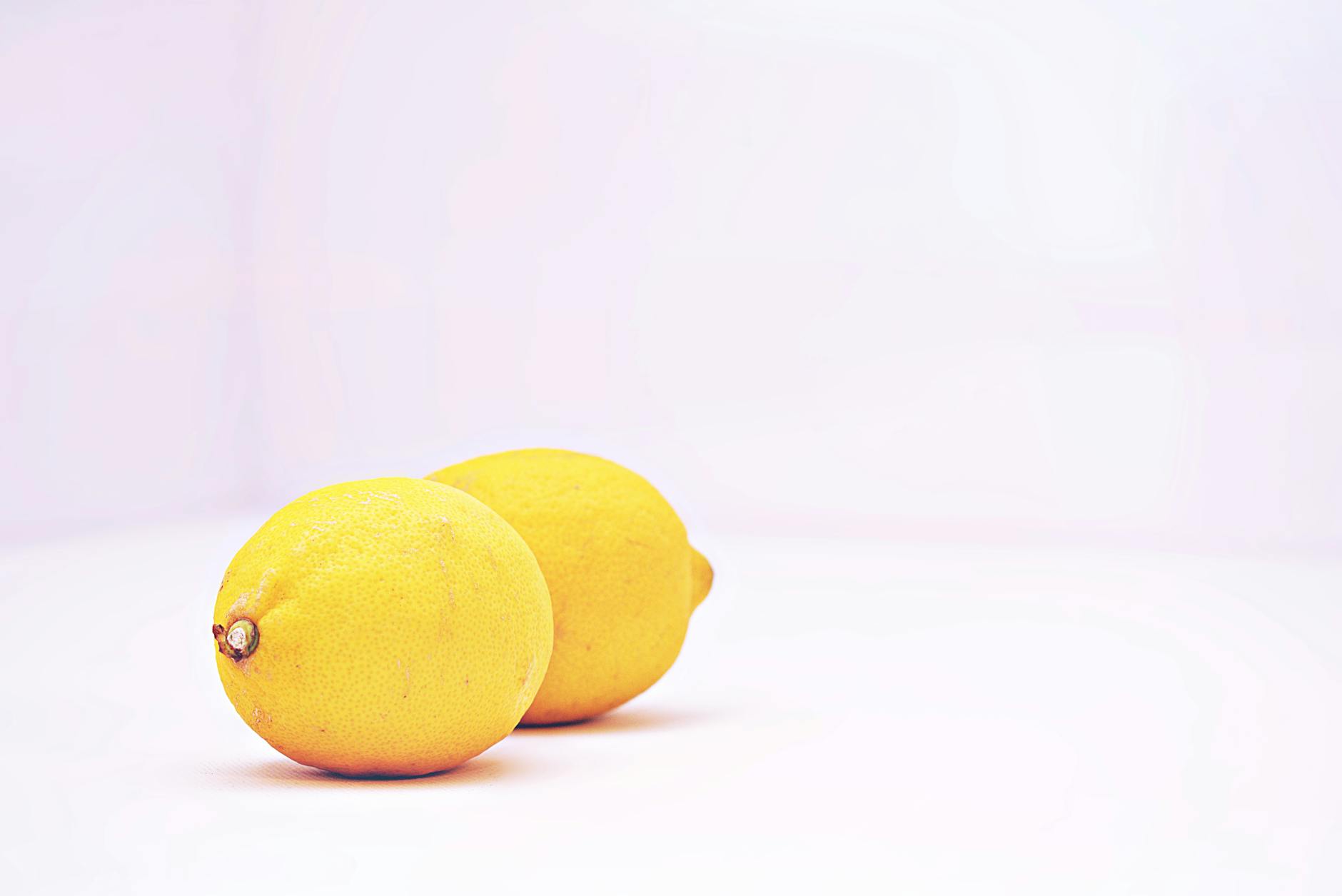 Bright yellow lemons on a white background, symbolizing freshness and vitality