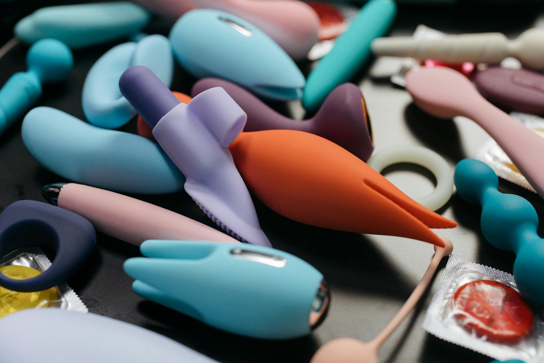 Two hands holding lemon vibrators together against a pastel background, representing shared pleasure